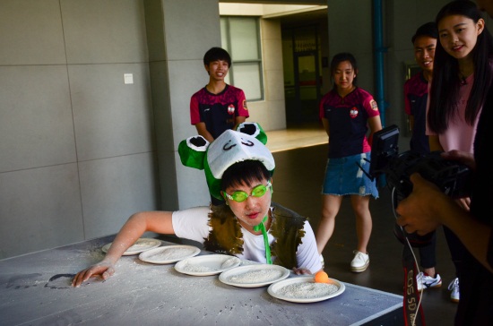主持人将乒乓球从装满面粉的盘子里依次吹到下一个盘子 孙建军 摄.jpg